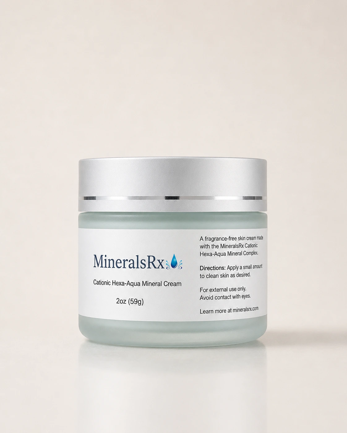 MineralsRx mineral cream in a frosted aqua glass jar with a silver lid, photographed on a warm neutral background